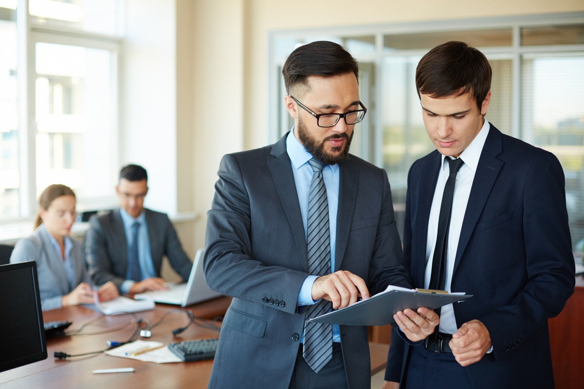 Two professionals reviewing documents on a tablet